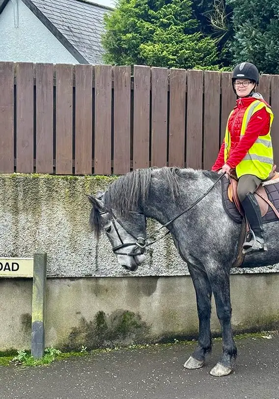Girl on horse standing at Irish Hill Road in County Antrim
