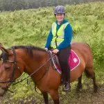 Girl in green jumper on brown horse in County Antrim